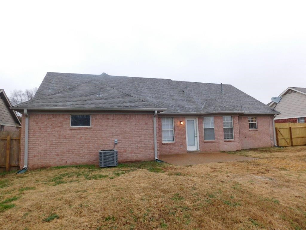 a brick house with a yard and a fence
