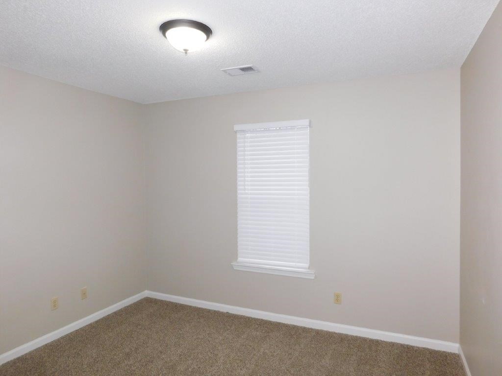 an empty room with a window and a carpet