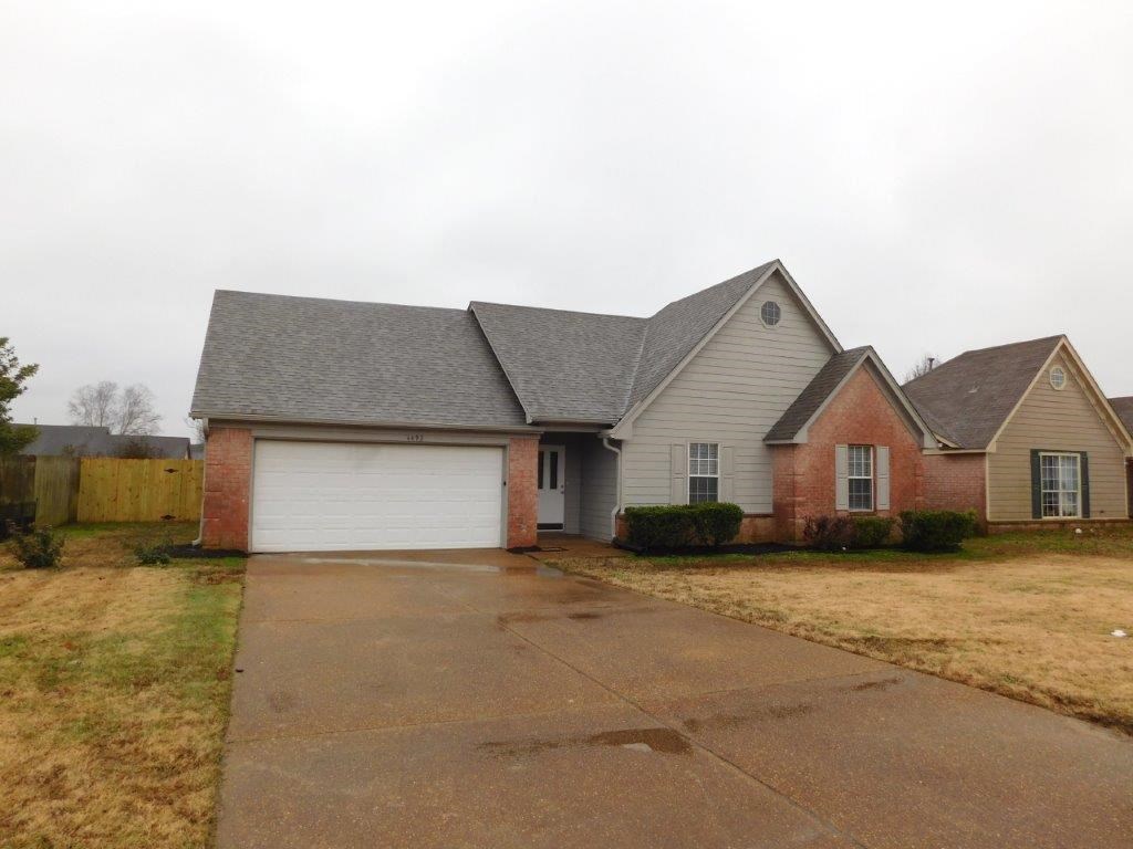 a house with a white garage door and a brick house