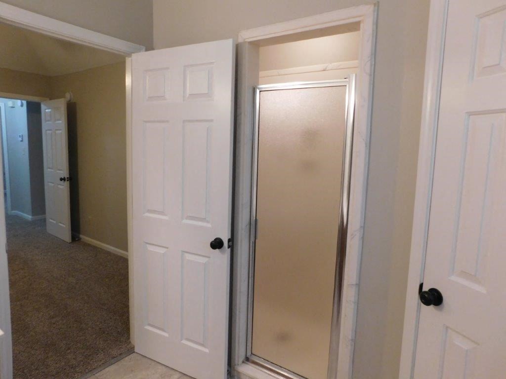 a bathroom with a closet and a white door