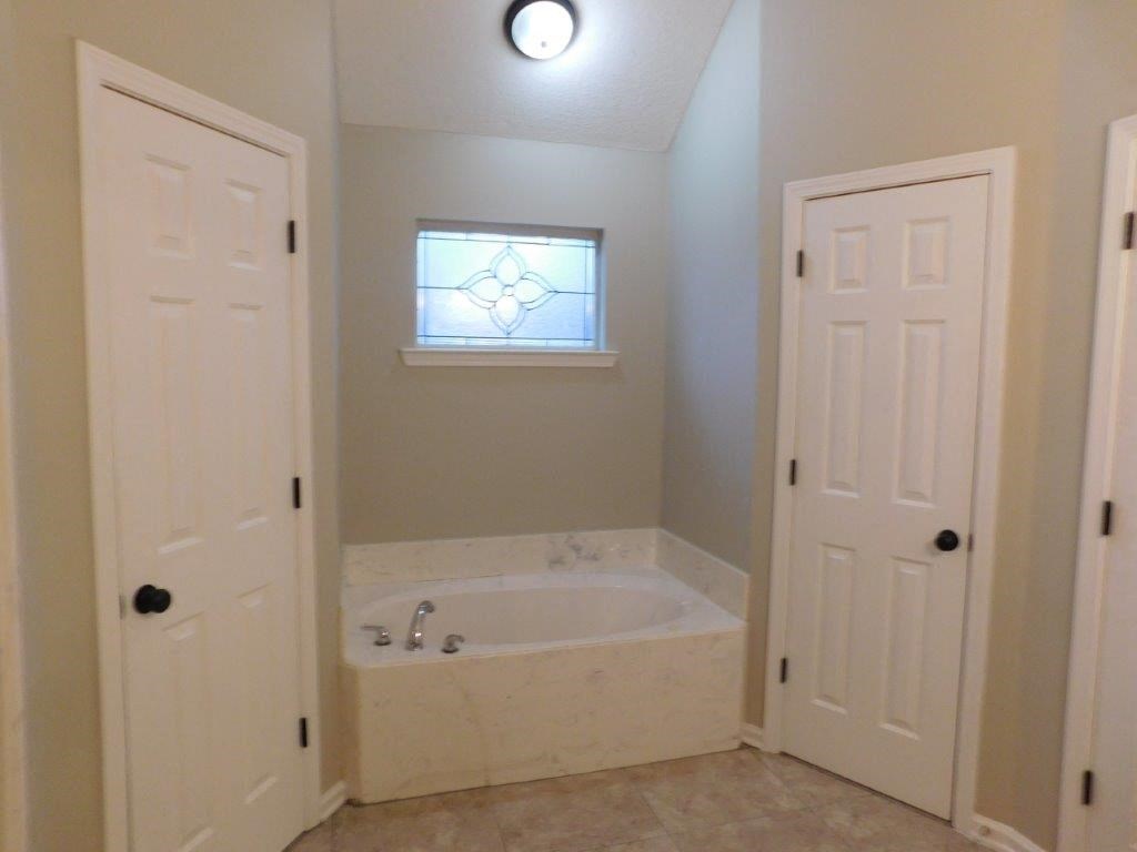 a bathroom with a tub and two doors