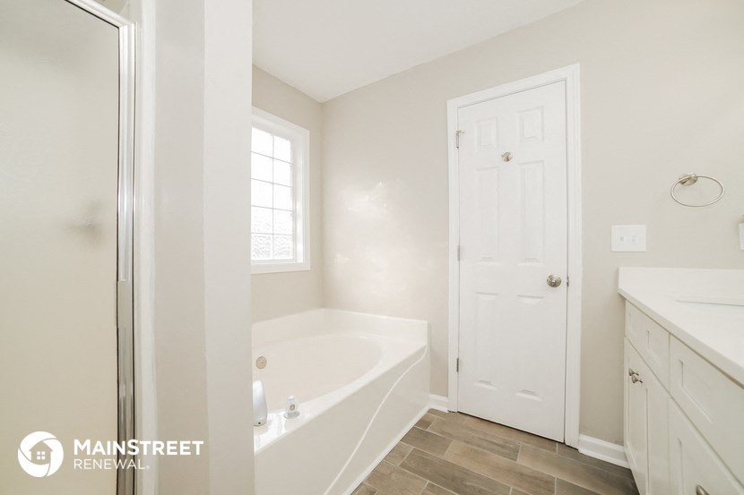 a bathroom with a tub and a shower and a sink