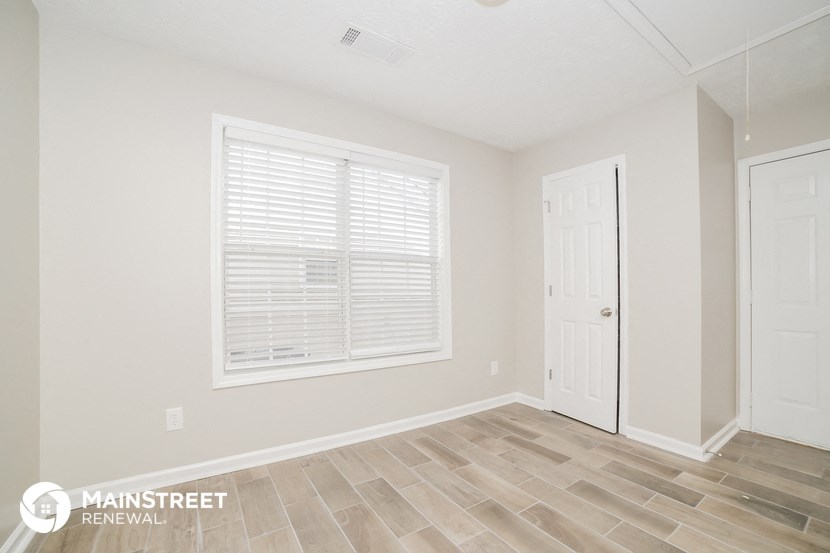the living room of a new home with a large window and a white door