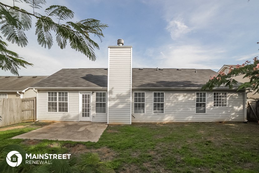 the exterior of a white house with a gray roof