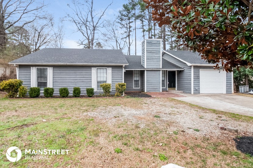 a blue house with a yard in front of it