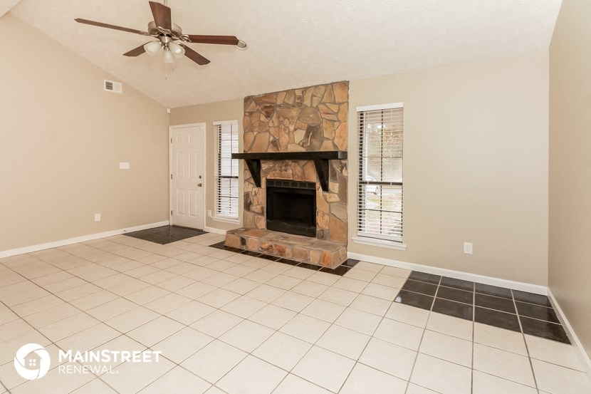 the living room has a fireplace and tile flooring