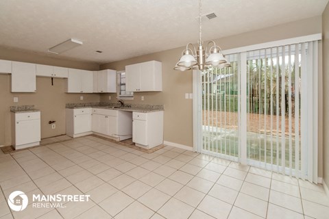 a kitchen with a sliding glass door to the patio
