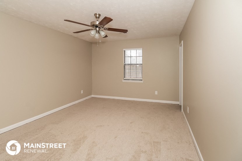 an empty room with a ceiling fan and a window