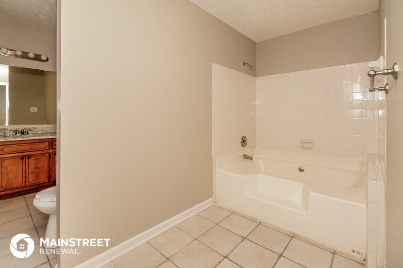 a bathroom with a tub and a sink and a toilet