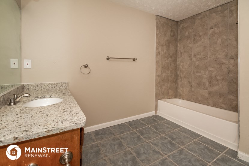 a bathroom with a sink and a tub and a mirror