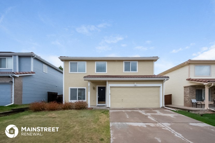 a home with a garage door and a lawn