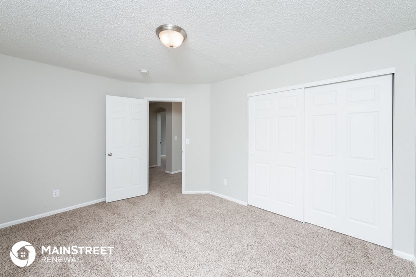 a bedroom with two closets and a carpeted floor