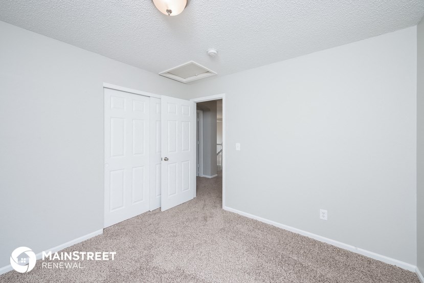 a bedroom with two closets and a door to a hallway