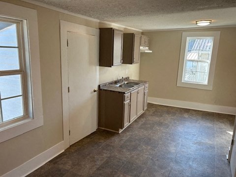 an empty kitchen with a sink and a window