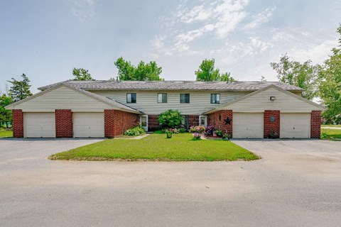 a white and brick house with a lawn in front of it