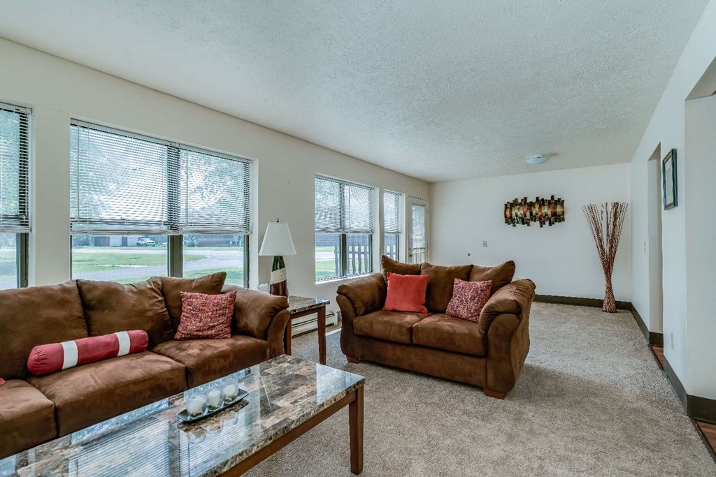 a living room with two couches and a glass table
