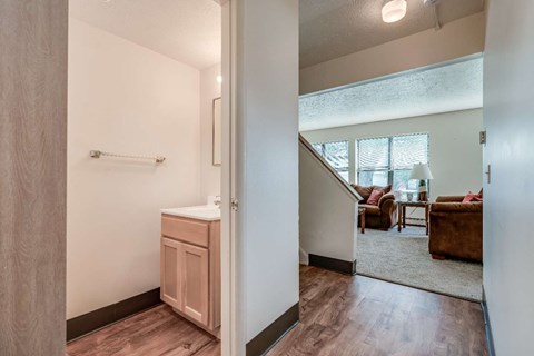 a view of a living room and a kitchen with a staircase
