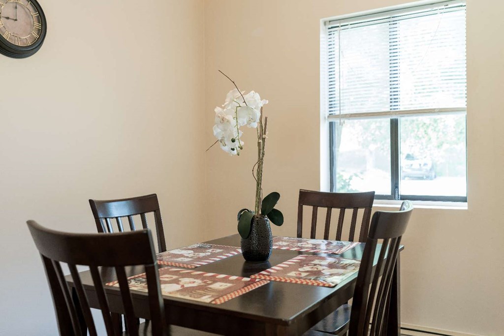 a dining room with a table and chairs and a window