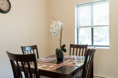 a dining room with a table and chairs and a window
