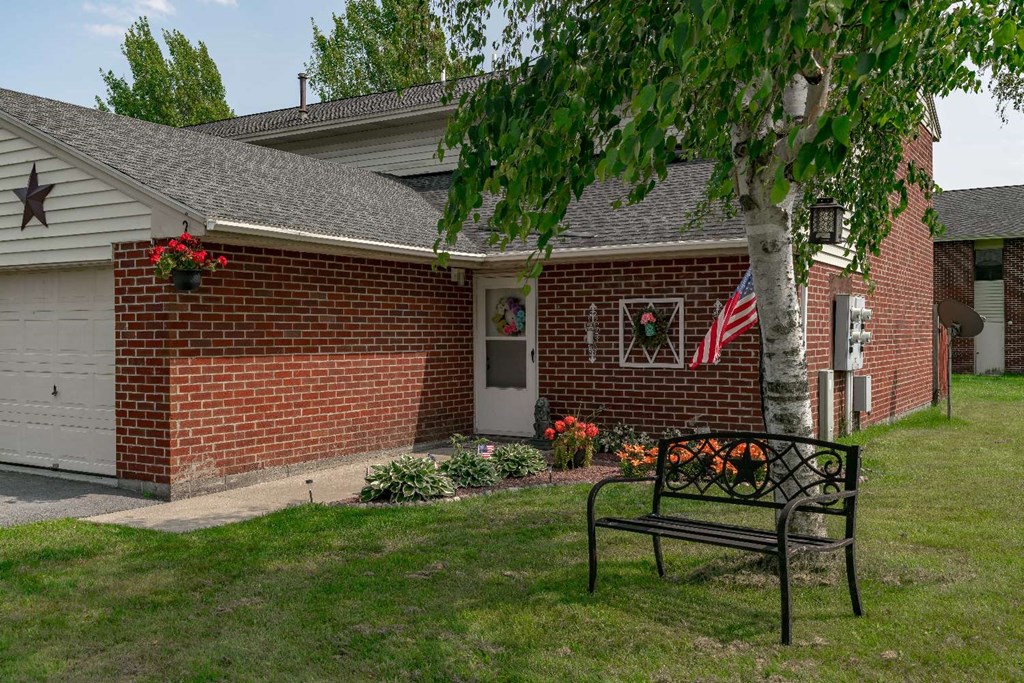 a bench sitting in front of a brick house