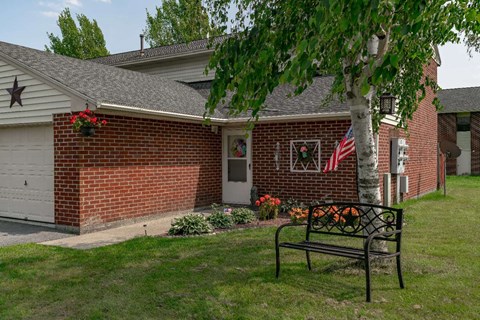 a bench sitting in front of a brick house