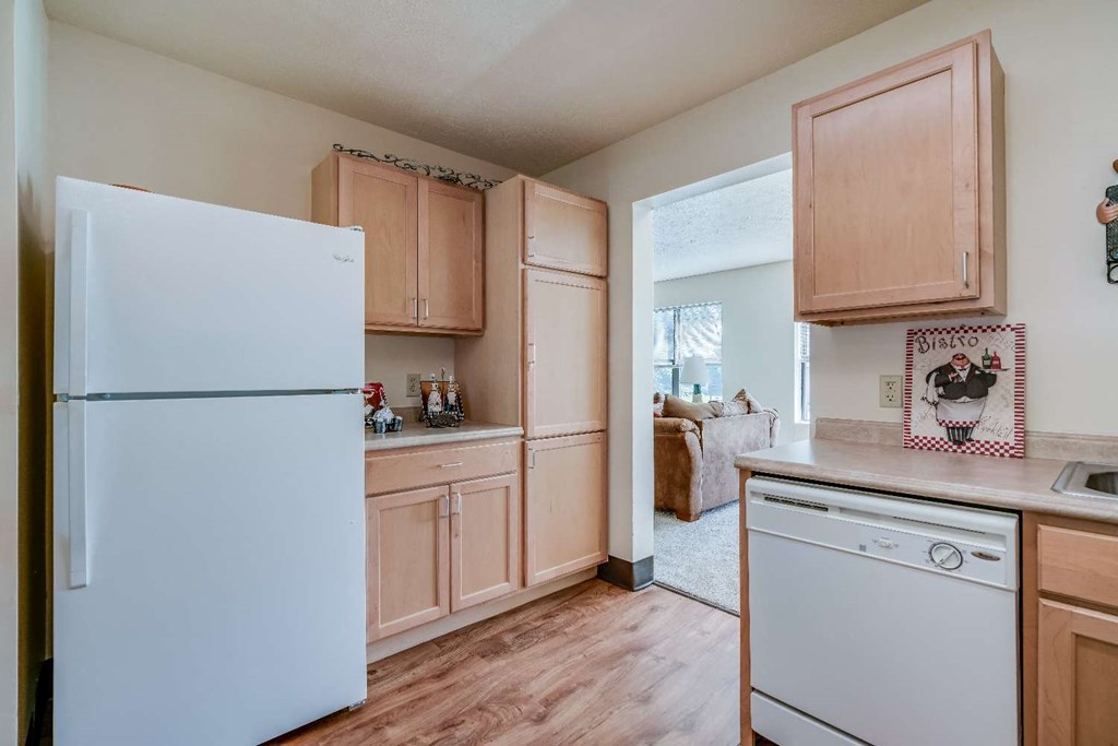 a kitchen with white appliances and wooden cabinets