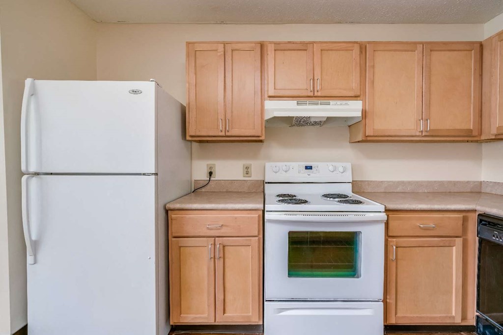 a kitchen with white appliances and wooden cabinets
