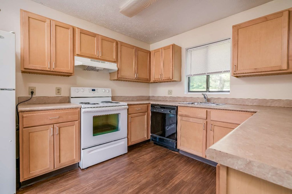 a kitchen with wooden cabinets and white appliances
