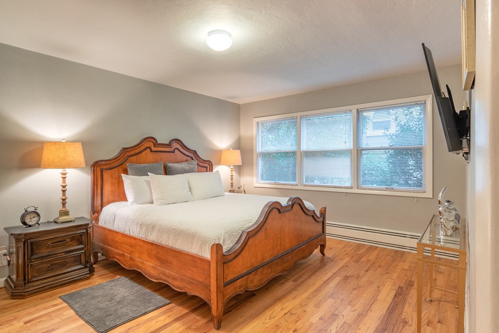 a bedroom with a bed and two windows