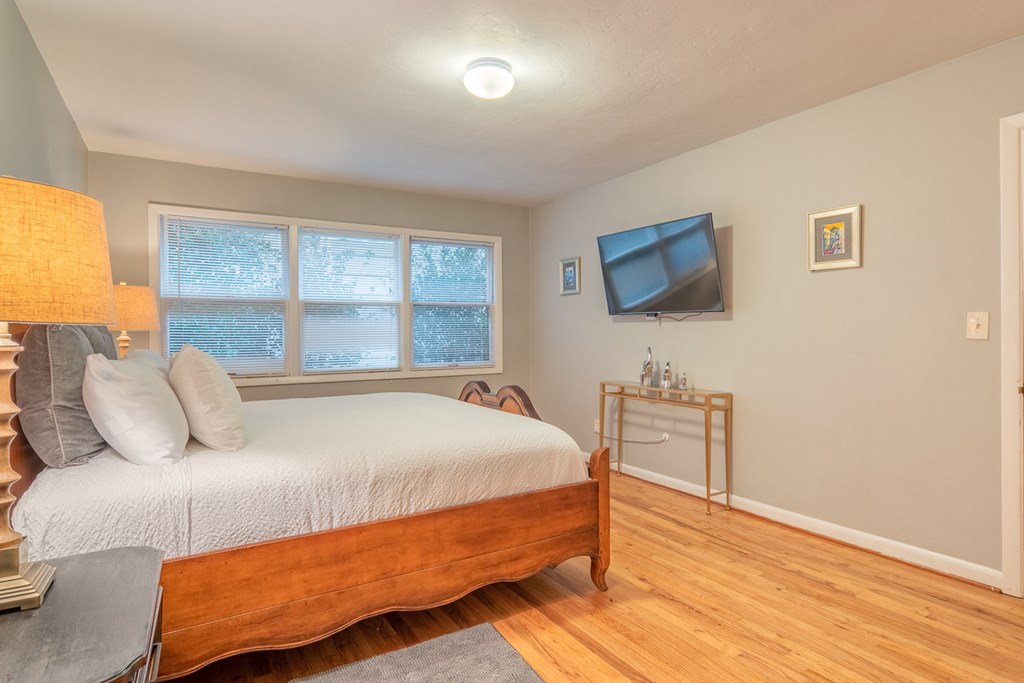 a bedroom with a bed and a tv on the wall
