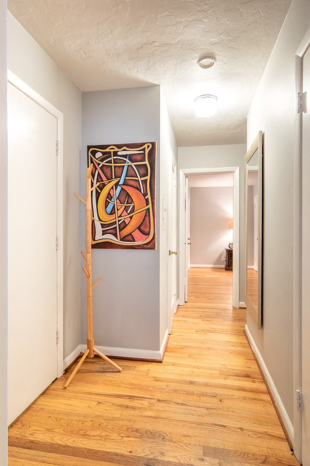 a hallway with wood floors and a painting on the wall