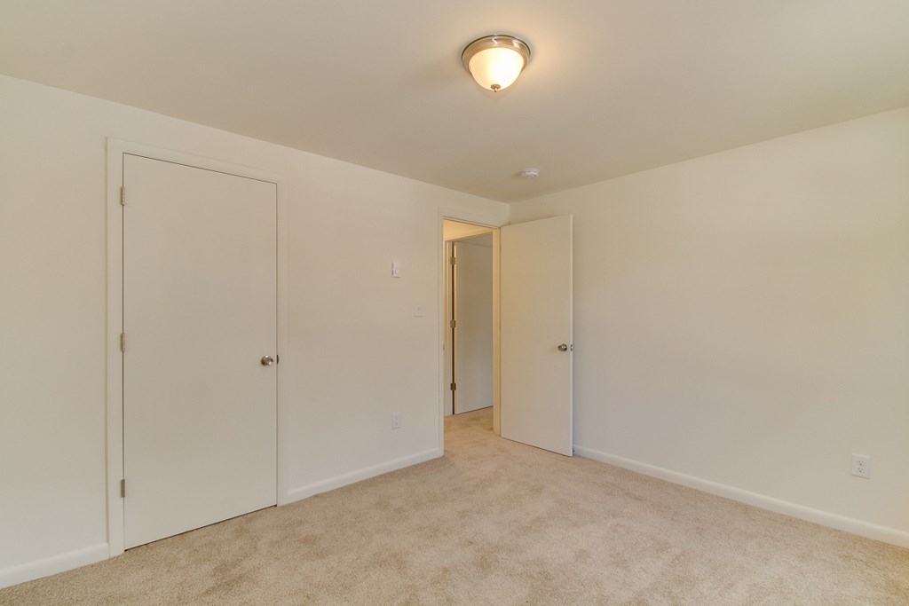 a bedroom with two closets and a door to a hallway