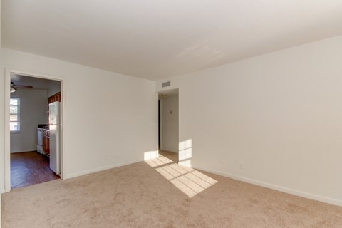 an empty living room with white walls and carpet