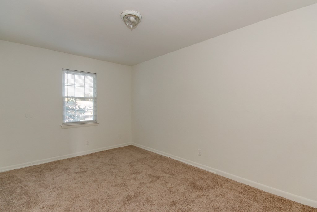 an empty room with carpet and a window