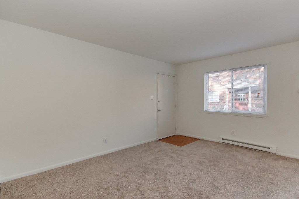 a bedroom with white walls and a window