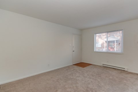 a bedroom with white walls and a window