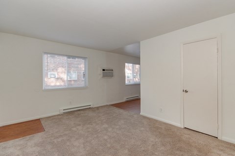an empty living room with a door and a window