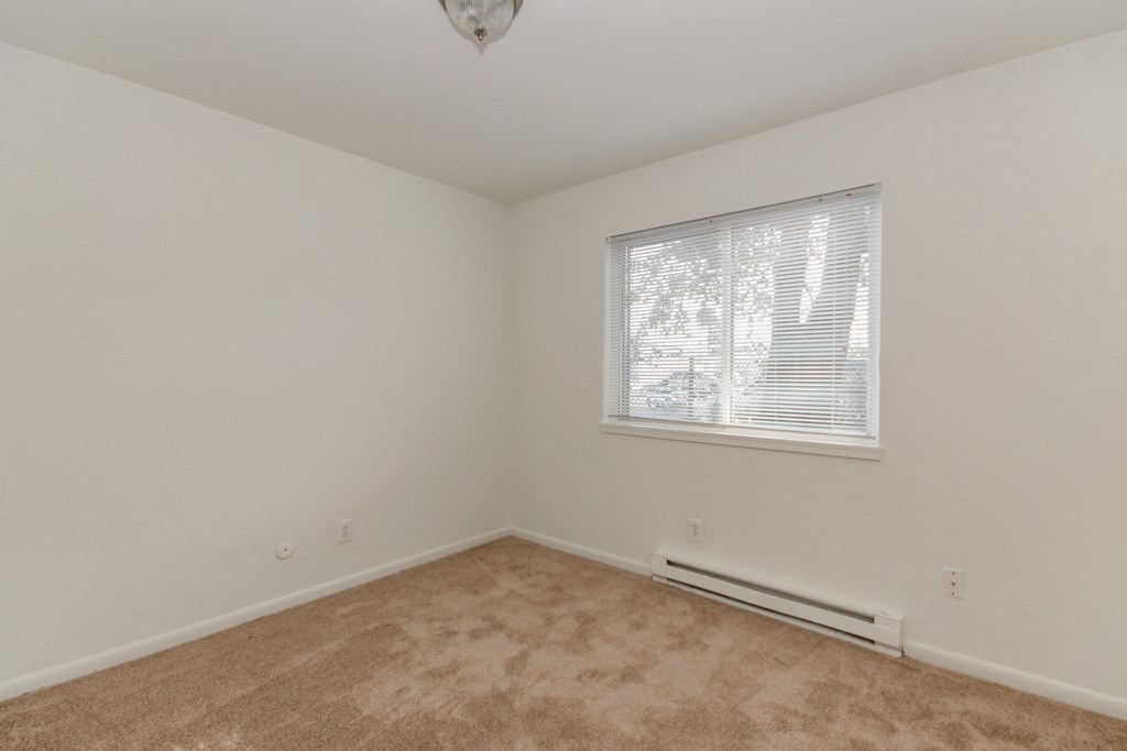 the living room of a home with carpet and a window