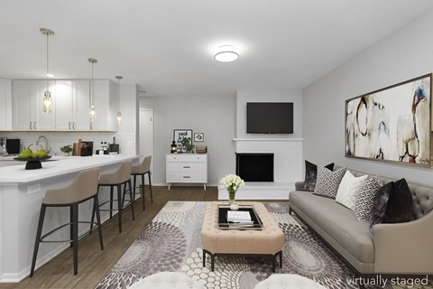 A modern living room with a grey couch, a coffee table, and a fireplace.