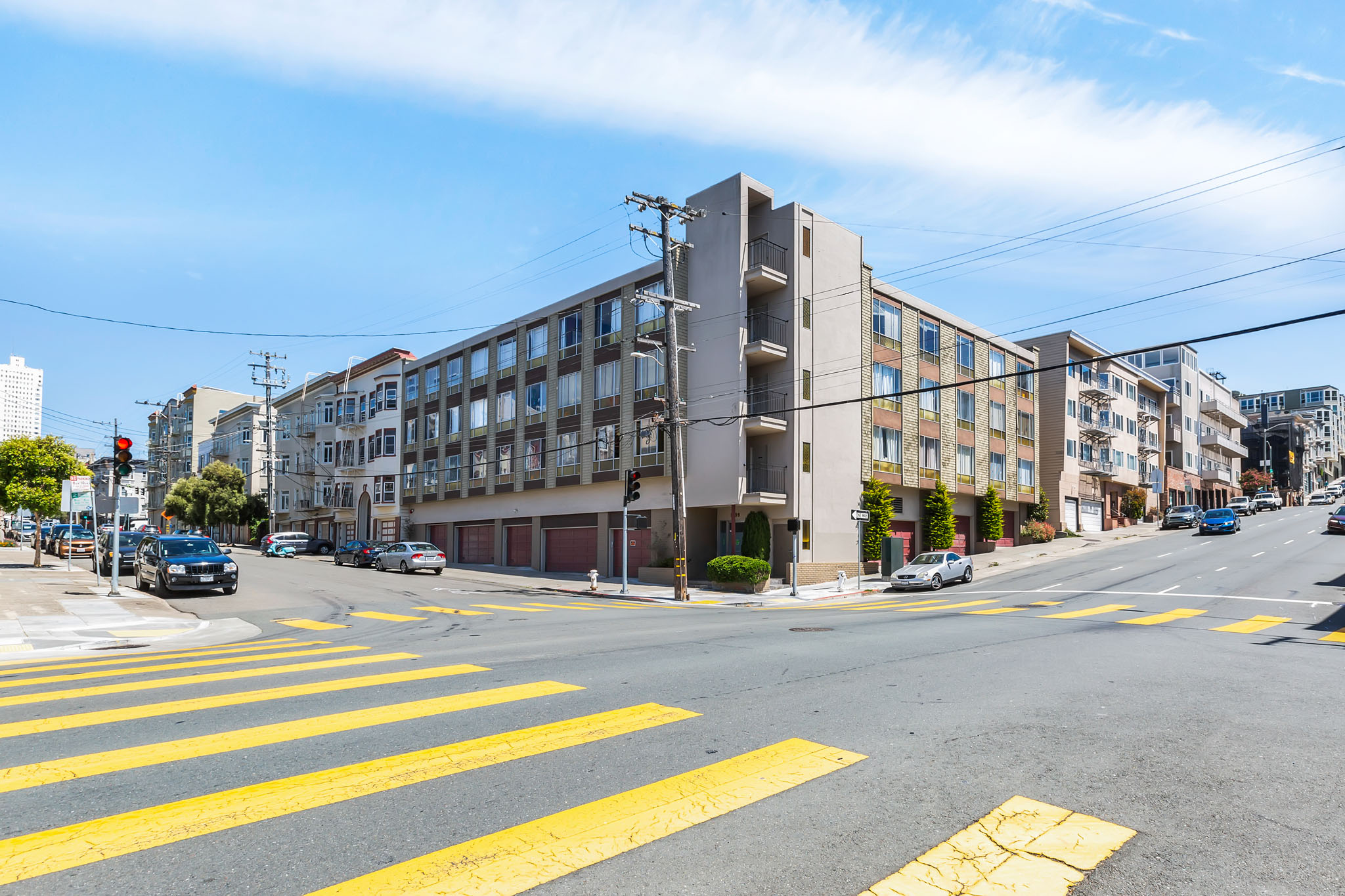 A street view with a crosswalk and cars on the road.