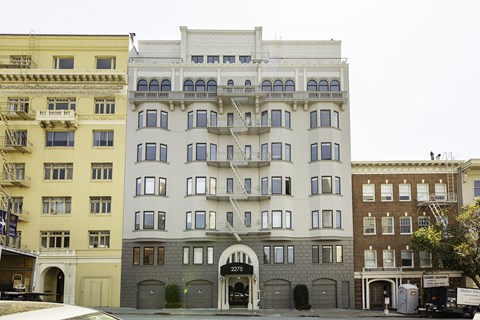 A row of buildings with the middle one being white.