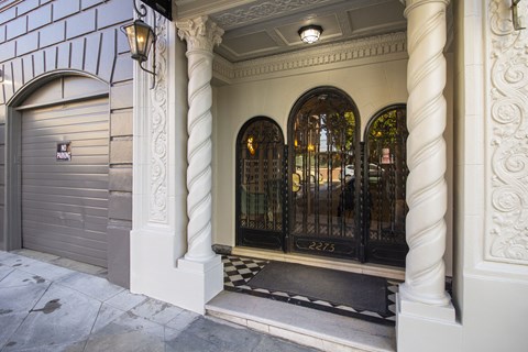 A building with a closed grey door and a black gate.