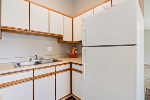 a kitchen with white cabinets and a white refrigerator