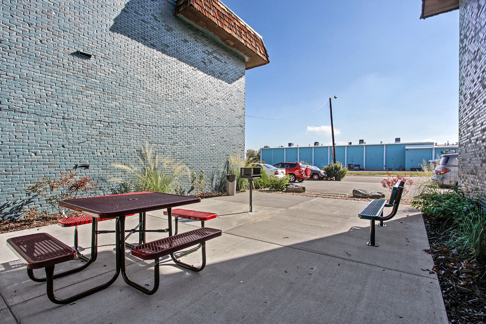 two picnic tables and benches outside of a building