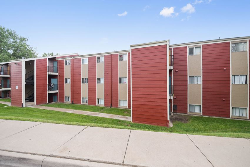 an exterior view of a row of red and beige apartment buildings