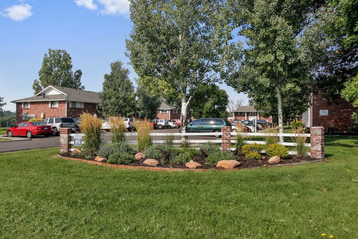 the front yard of a house with a garden and a fence