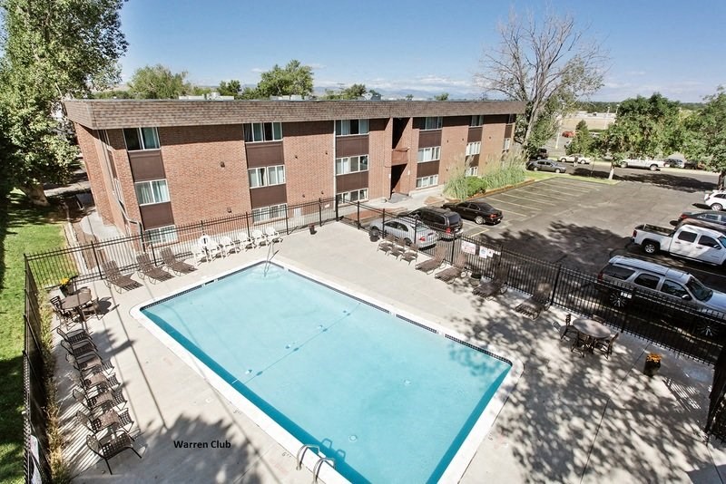 a pool is shown in front of a brick building