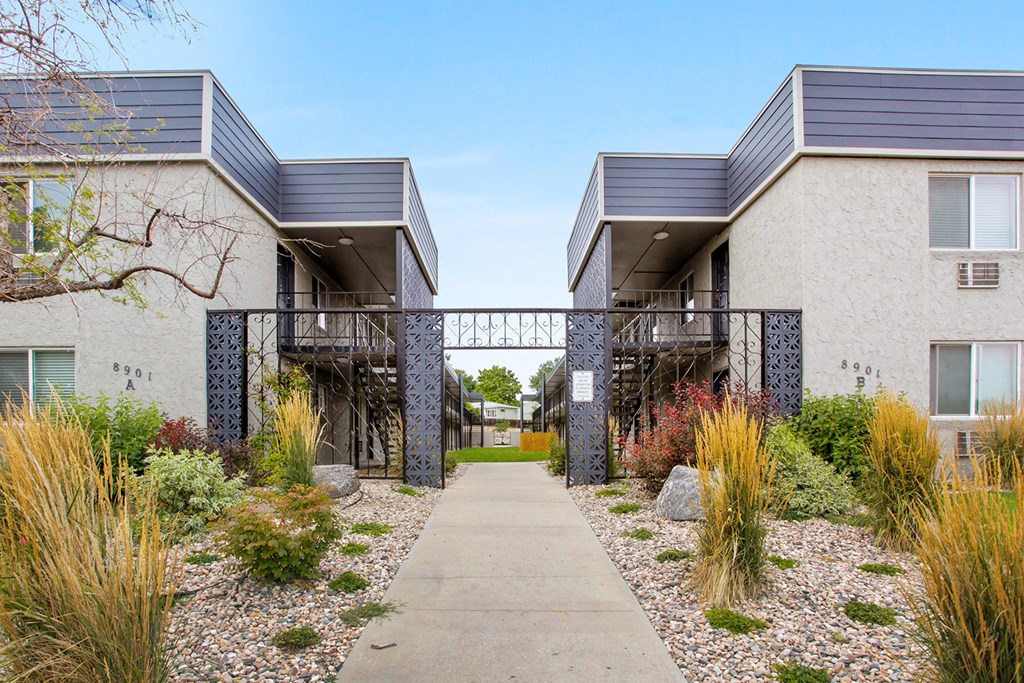 a sidewalk in front of two buildings with a bridge between them