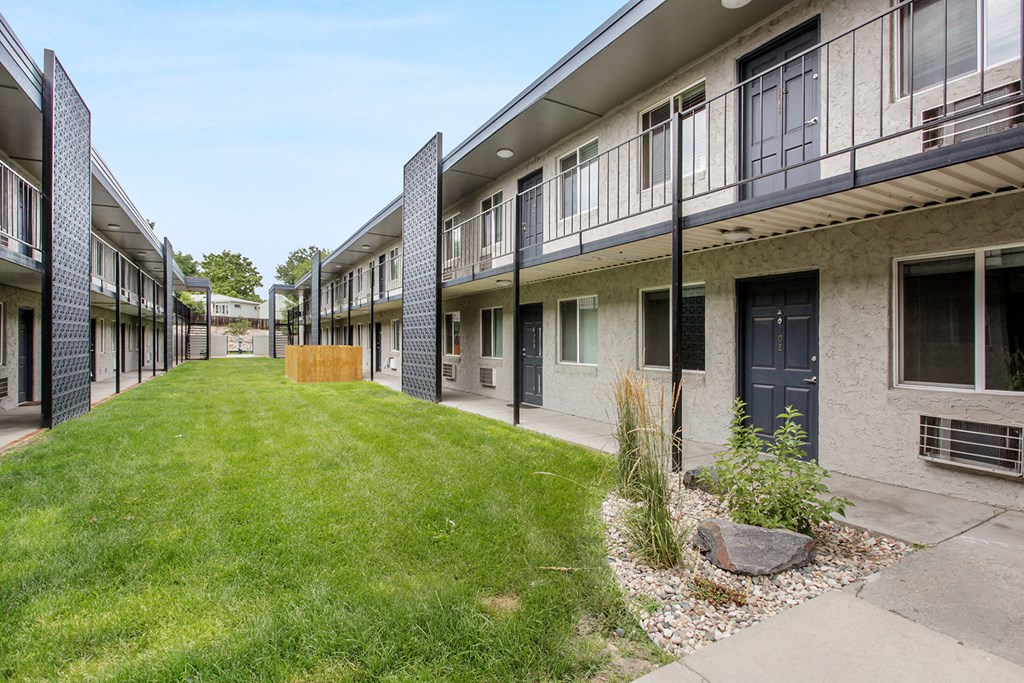the courtyard of a condo building with a lawn and a sidewalk