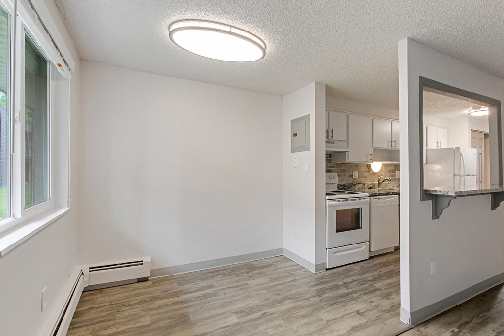 an empty living room and kitchen with a large window